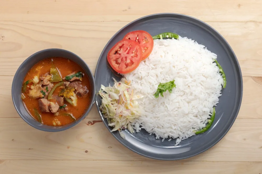 Traditional Ugandan goat stew with rice and fresh soup at 7Days Motel