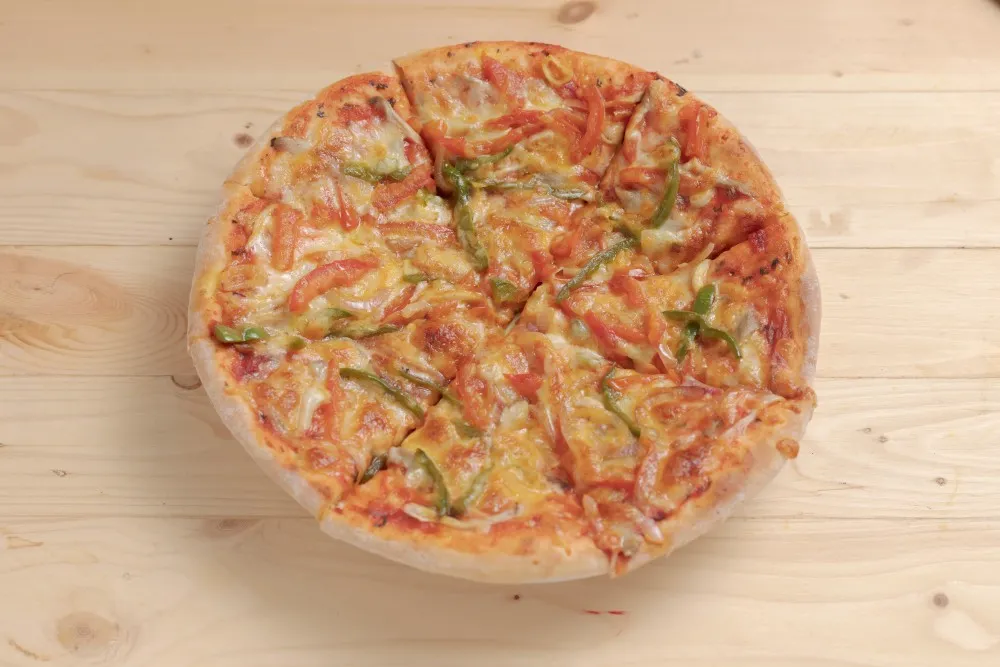 Freshly baked vegetable pizza with melted cheese at 7Days Motel restaurant